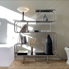 a metal shelf with books and vases on it