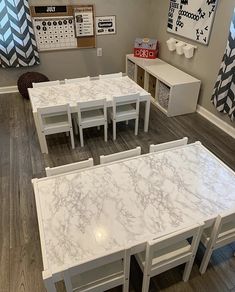 a room filled with white tables and chairs