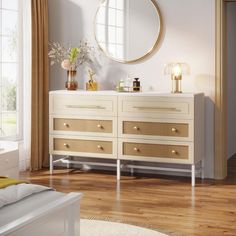 a white dresser sitting in front of a mirror on top of a hard wood floor