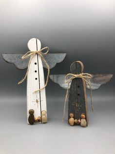 two wooden angel figurines sitting next to each other