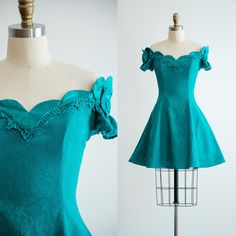 A cute little 80s party dress, made from bright green floral brocade. It has a scalloped, off-shoulder neckline, trimmed in glossy satin, with bows on the sleeves. It has a nipped waist with boning in the bodice, and flared skirt with tulle underneath. Fully lined. ☛ m e a s u r e m e n t s ☚ Best for: S Bust: 36 Waist: 28 Hips: free Length: 31 ☛ d e t a i l s ☚ Era: 1980s Material: cotton, acetate Brand: ZumZum Condition: excellent ☛ v i s i t   t h e   s h o p ☚ https://etsy.me/2Nd23kg ☛ instagram ┇ poppycockvintage ☛ facebook ┇ poppycockvintage 80s Party Dress, Confirmation Dresses, Mini Party Dress, 80s Party, Mini Party, Green Mini Dress, 80s Dress, Dance Fashion, 80s Vintage