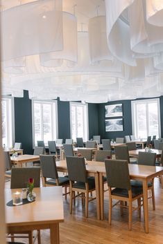 an empty dining room with wooden tables and chairs