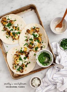 two tacos are sitting on a tray with sauces