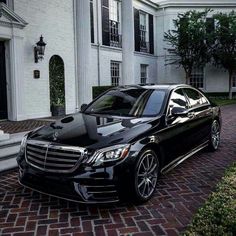 a black car parked in front of a white house