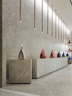 the interior of a women's clothing store with marble counter tops and handbags on display