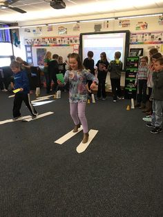 a group of young children standing in front of a whiteboard