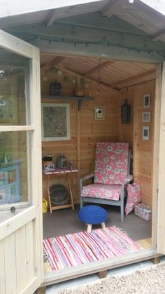 the inside of a small wooden shed with furniture