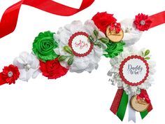 red, white and green flowers are on display with ribbons in the shape of hearts