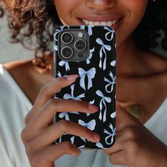 a close up of a person holding a cell phone in their hand and smiling at the camera