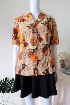 Stunning True Vintage blouse from the 1970s. Comfortable fabric, probably cotton or cotton mix. Amazing floral print in a beautiful color mix with ton-sur-ton embroidered structures in the fabric. Beautiful large golden buttons. BRAND: No brand label, probably custom made ERA: 1970s COLOR: Sand, brown, orange, yellow, blue FABRIC: No fabric tag, probably cotton or a cotton mix SIZE: No size tag, fits best size M - please check measurements below MEASUREMENTS: Pit to pit 48cm, total length 63cm C Vintage Collared Top With Floral Print, Retro Collared Blouse With Floral Print, Retro Button-up Blouse With Vintage Print, Brown Vintage Blouse For Spring, Retro Brown Summer Blouse, Summer Retro Brown Blouse, Vintage Cotton Blouse With Vintage Print, Vintage Cotton Patterned Blouse, Vintage Patterned Cotton Blouse