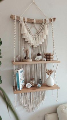 a macrame wall hanging with tassels and other things on it in a living room