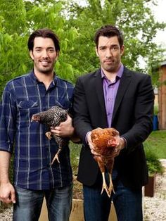 two men standing next to each other holding chickens