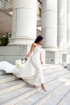 a woman in a wedding dress walking up some steps