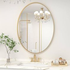 a white bathroom with a round mirror above the sink and gold accents on the counter