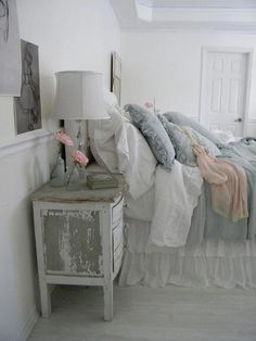 a bed room with a neatly made bed next to a night stand