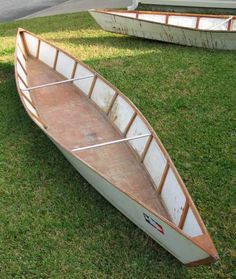 two canoes sitting on the grass next to each other