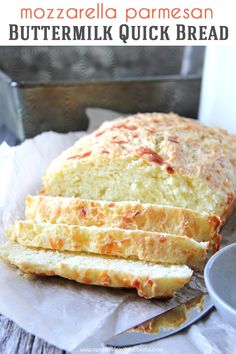 a loaf of bread sitting on top of a piece of paper next to a cup