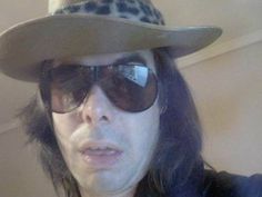 a man with long hair wearing sunglasses and a hat on his head is taking a selfie