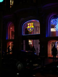 people are standing in front of a building at night