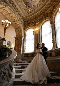 the bride and groom are standing on the stairs