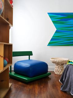 a room with wooden floors and white walls, including a blue bean bag on the floor