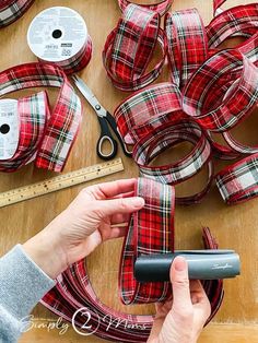 a person is working on some red plaid ribbon