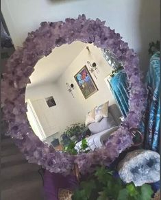 a mirror that is sitting in the middle of a room next to a potted plant