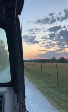 a truck driving down a country road at sunset