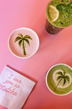 three cups with different drinks in them on a pink surface