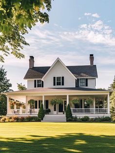 a large white house sitting on top of a lush green field