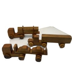 three wooden toy trucks are shown on a white surface and one is made out of wood