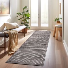 a living room with wooden floors and a rug on the floor next to a door