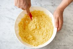 a person mixing food in a white bowl