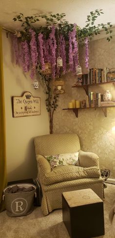 a living room filled with furniture and lots of purple flowers hanging from the ceiling above