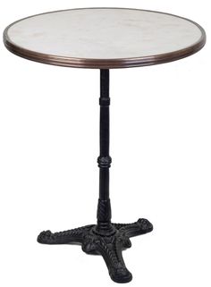 a white marble top table with black metal legs and an ornate design on the base