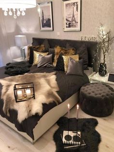 a bedroom with a bed, candles and pictures on the wall above it is decorated in black and white