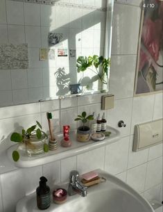 a white sink sitting under a bathroom mirror