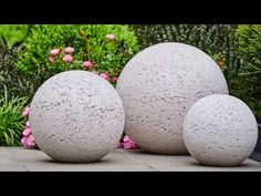 three cement balls are sitting on the ground