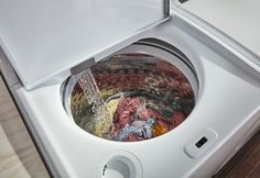 a washing machine filled with lots of different colored things in it's front compartment