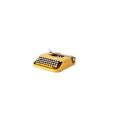 an old fashioned yellow typewriter with black and white checkers on the keys, against a white background