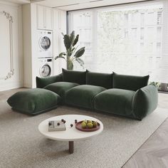 a large green couch sitting in a living room next to a white coffee table