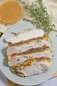 a white plate topped with sliced meat next to a cup of tea