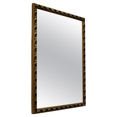 a mirror that is sitting on top of a wooden frame and has black trim around the edges