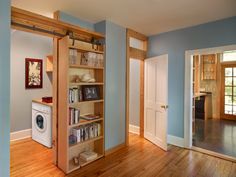 an empty room with blue walls and wood floors