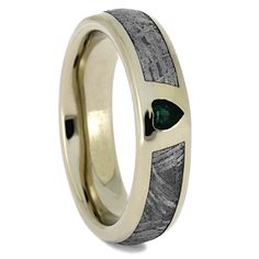 a wedding ring with an arrow and green stone inlay