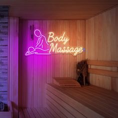 a sauna with a neon sign that says body massage on the wall next to it