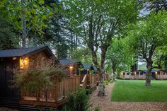 a wooden cabin surrounded by trees and grass