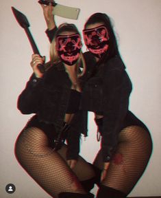 two people wearing neon masks and holding knives