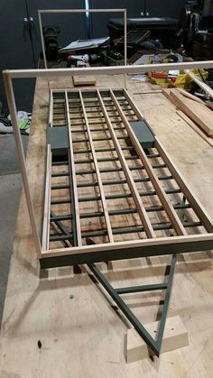 an unfinished bed frame sitting on top of a wooden table