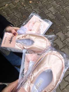 a pair of pink ballet shoes sitting on top of each other next to a package